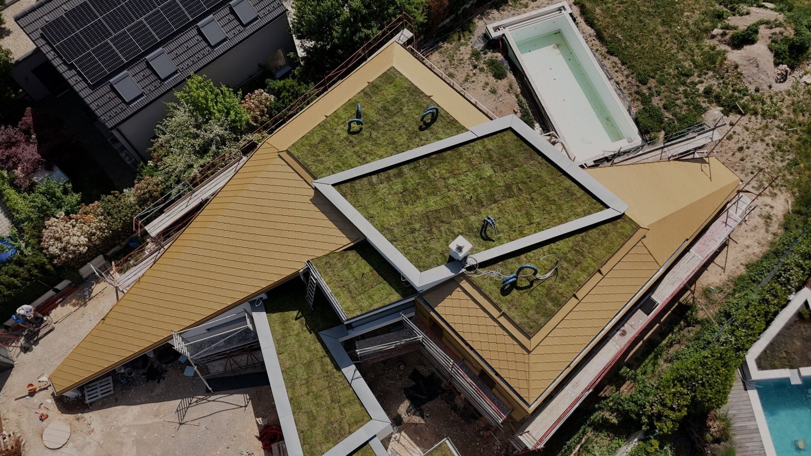 Einfamilienhaus mit goldfarbener Aluminium-Rautendeckung und Gründach, von oben